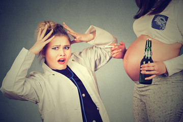 Closeup surprised doctor and pregnant woman with bottle of beer and cigarette