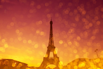 Eiffel Tower silhouette at evening sunset light in Paris France with shiny golden glitter double...