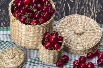 Fototapeta na wymiar Cherry baskets on wooden background
