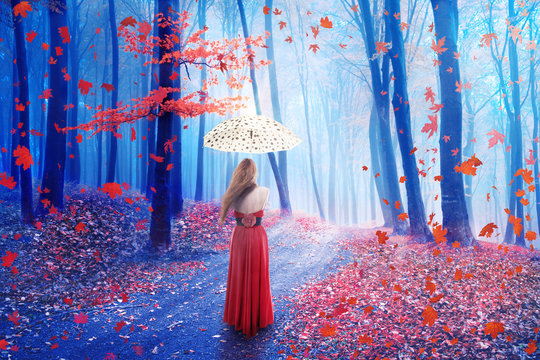 Fantasy image lonely woman with umbrella walking in forest in fairy dreamy realm.