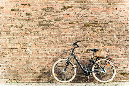 Black retro vintage bicycle with old brick wall.