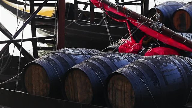 Wood barrel with port wine on the boat in the river Douro. Porto