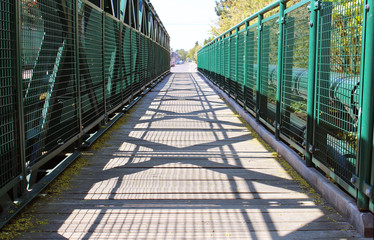 Fototapeta na wymiar Empty walking road across the green bridge