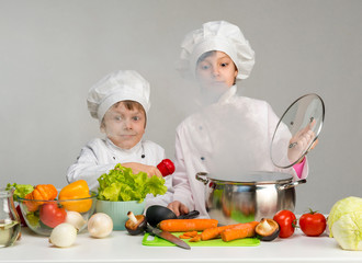little cooks by the kitchen table in steam from open pan
