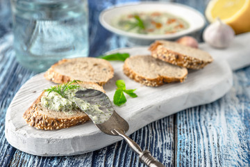 Bread with tzatziki on the white wooden board on the blue table horizontal