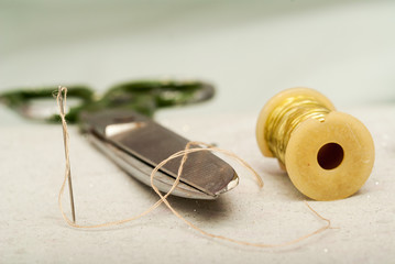 Scissors reel of thread, measuring tapes and natural fabric. Sewing textile or cloth. Work table a tailor.