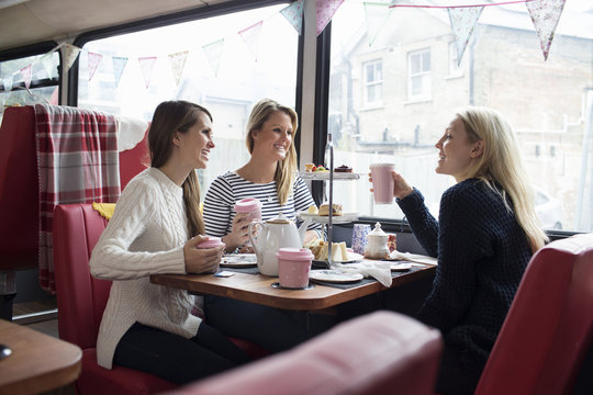 Group Of Young Female Friends Meeting In Tea Shop