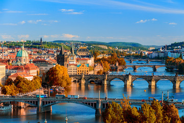 Obraz premium Widok na Wełtawę i most Charle z czerwonymi liśćmi, Praga, Czechy