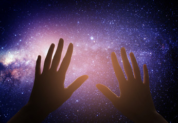 Hand reaching for the  sky with dark stormy clouds