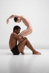 Naklejka premium Couple of ballet dancers posing over gray background