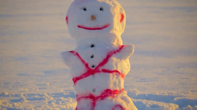 A spiky hair snowman with pink paint on his body with drawings of hearts on his lower part