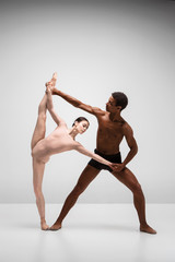 Naklejka premium Couple of ballet dancers posing over gray background