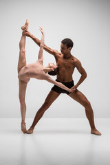 Fototapeta premium Couple of ballet dancers posing over gray background