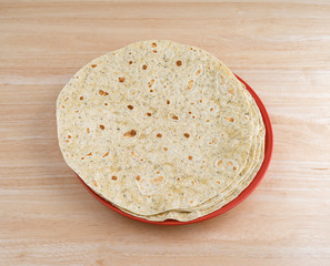 Garlic and herb flavored tortilla wraps on a colorful plate atop a wood table top