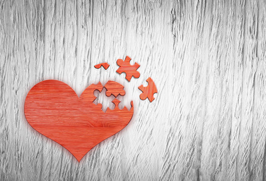 Wooden puzzle heart on grey wooden background