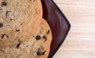 Top close view of gluten-free chocolate chip cookies on a plate atop a wood table top