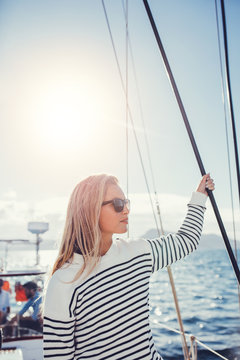 Attractive young woman standing on a yacht