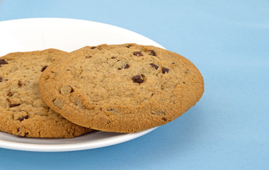 Gluten-free chocolate chip cookies on a plate atop a blue tablecloth