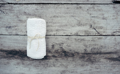 Top view of white towel roll tied with rope on old wooden table