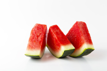 Three slices of watermelon setting vertical on a white background