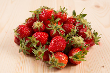 Ripe strawberry fruits, flowers, leaves on white wood table background