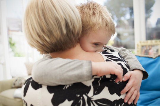Young Boy Giving Mother Hug At Home