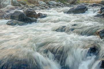 River water flowing through rocks at dawn