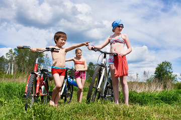 Children with bicycles outdoors on sunny day
