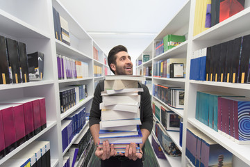 Student holding lot of books in school library