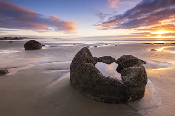 Poster de jardin Nature NEW ZEALAND, 22TH APRIL 2015: Moeraki Boulders on the Koekohe beach, Eastern coast of New Zealand. Sunrise and long exposure