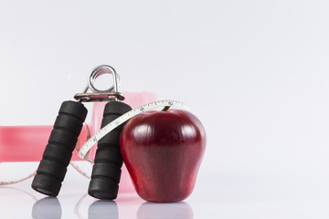Fitness background with bottle of dumbbell, handgrip and apple