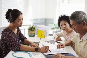 Serious Senior Couple Meeting With Doctor In Office