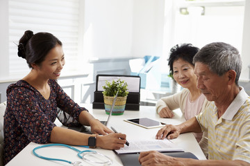 Senior Couple Meeting With Doctor In Office