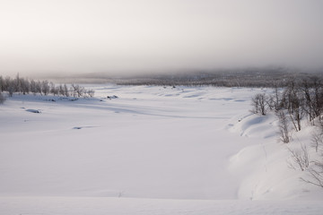 Fototapeta na wymiar nebliger Morgen an einem zugefrorenen See in Schweden