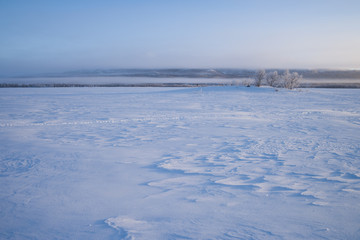 nebliger Morgen an einem zugefrorenen See in Schweden