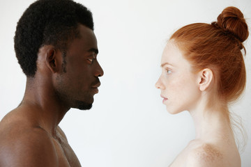 Deep connection between two young people of different races looking at each other with pure...