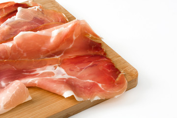 Thin slices of spanish serrano ham on a table isolated on white background
