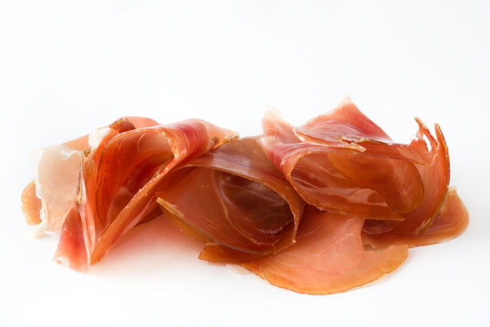 Thin slices of spanish serrano ham isolated on white background
