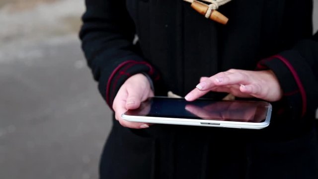 Girl is Walking and Using a Tablet