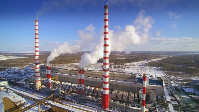 Smoke coming out of the electric power plant. Electricity is produced at a an electric power plant. Some fuel source such as coal oil natural gas or nuclear energy produces heat.