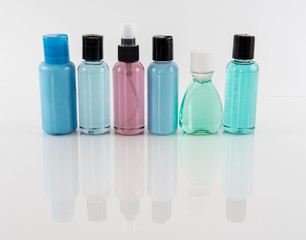Travel Toiletry Bottles on Reflective Surface