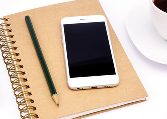 Smart phone and notebook with empty screen on white table