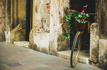 Lonely bike awaiting its owner, based on the old wall background