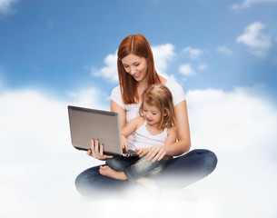 happy mother with adorable little girl and laptop