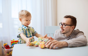 father and son playing with ball clay at home