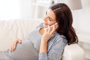 happy pregnant woman calling on smartphone at home