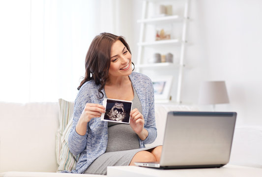 pregnant woman with ultrasound image and laptop