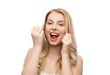 happy young woman with dental floss cleaning teeth