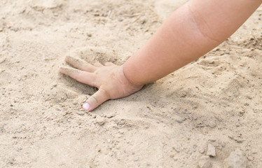 Asian child playing with sand in the playground