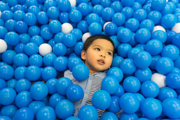 Fototapeta na wymiar Boy playing in the playground balls pool